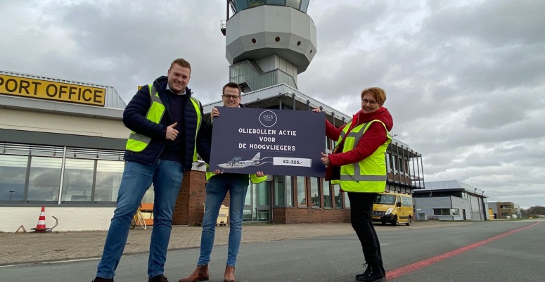 Vrijwilliger Janet neemt de cheque ik ontvangt op Groningen Airport Eelde